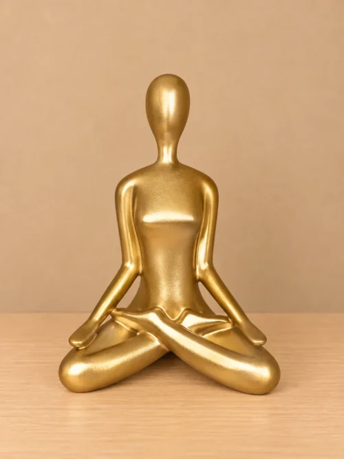 Zlatna figura u meditaciji Zlatna dekorativna figura u meditativnoj pozi sa prekrštenim nogama