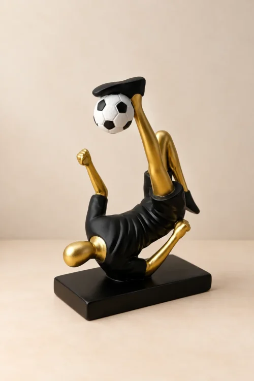 Figura fudbalera u makazicama Crno-zlatna dekorativna figura fudbalera u makazicama sa fudbalskom loptom